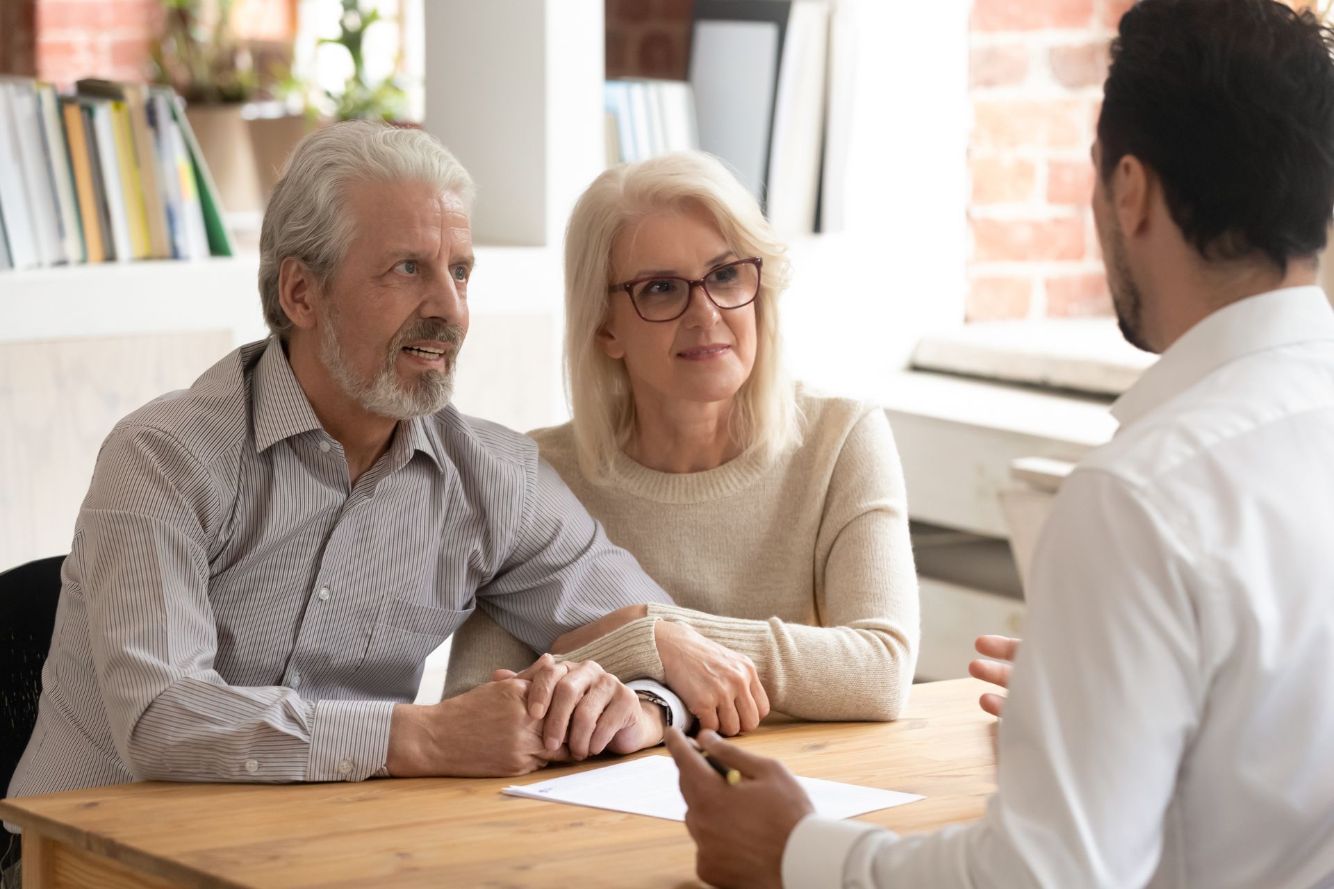 Senior couple meeting with a Senior Move Manager at a table, discussing plans for relocation