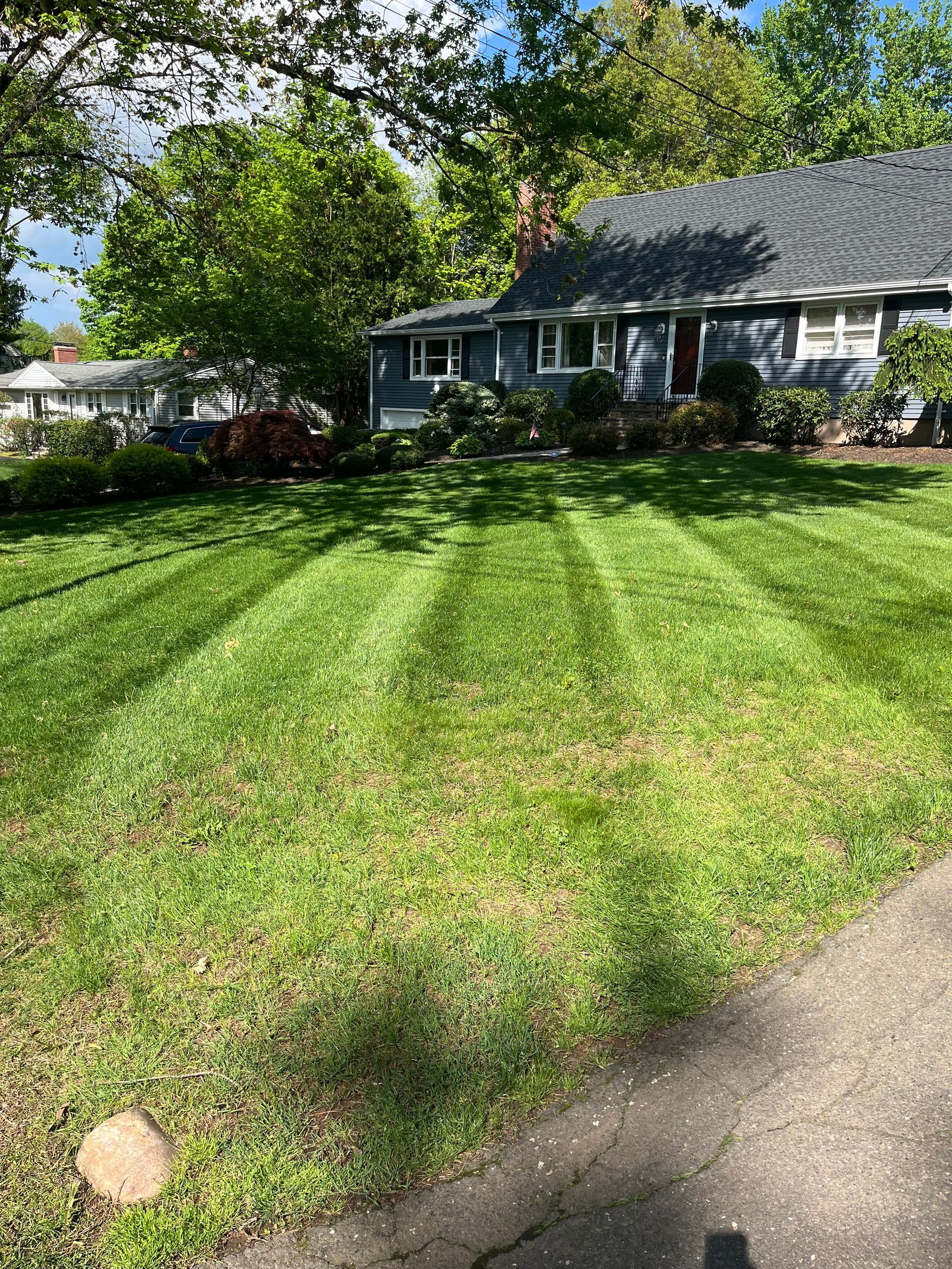 A house with a lush green lawn in front of it.