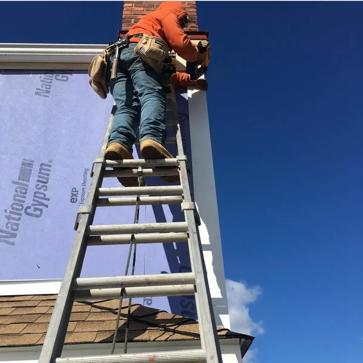 A man is on a ladder working on a chimney