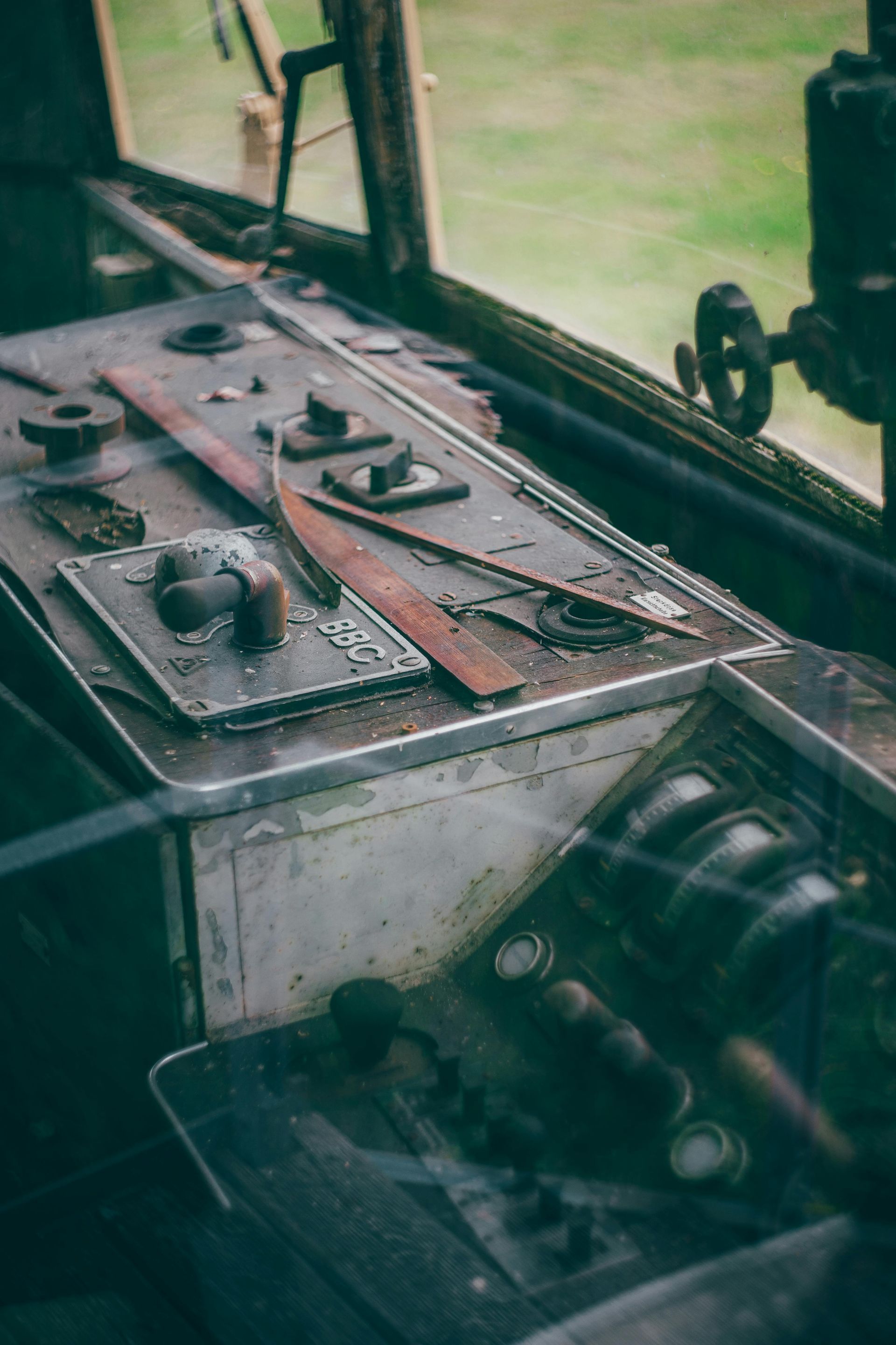 Close-up of an old vehicle control panel with levers and gauges by a window