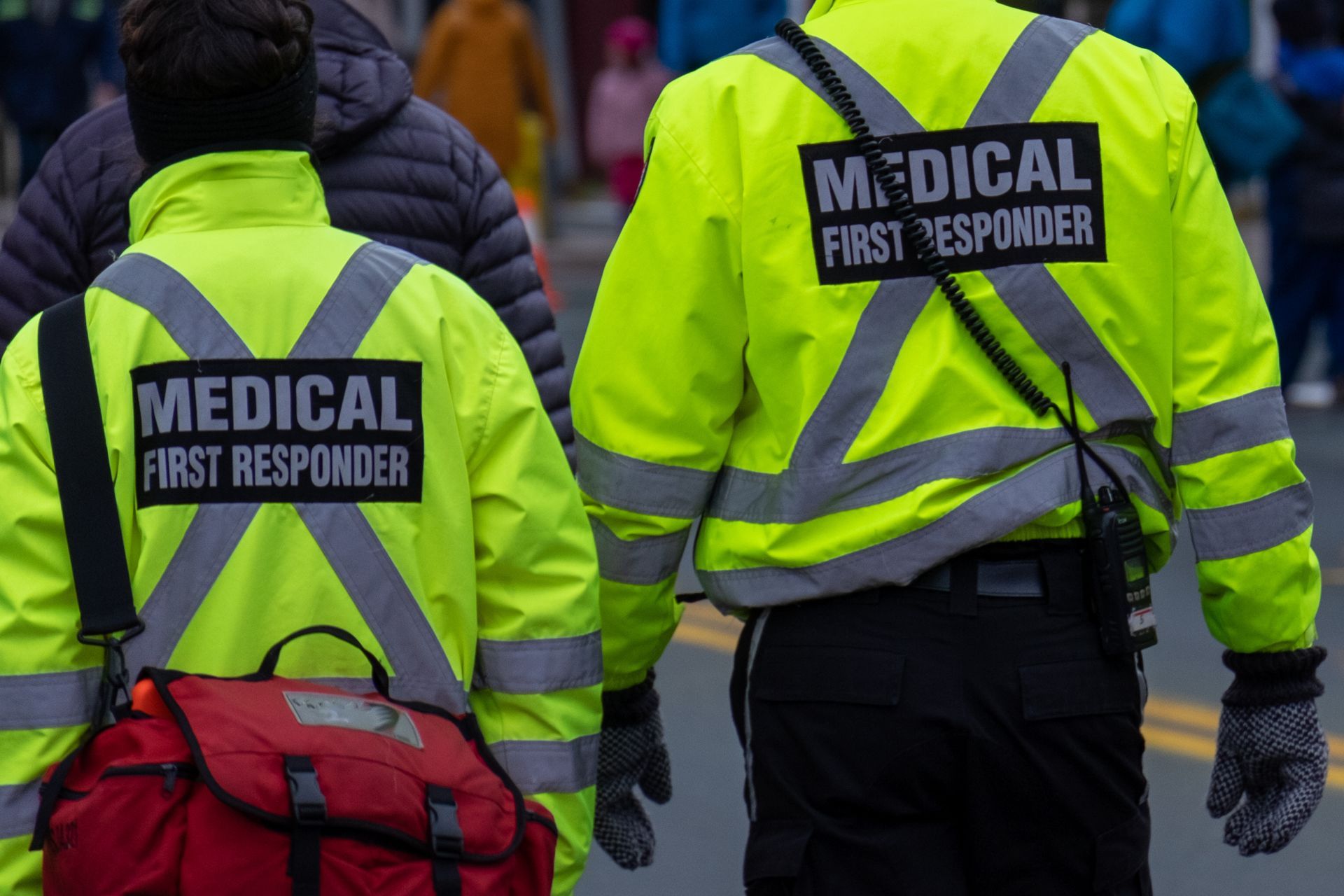 Two medical first responders are walking down the street.