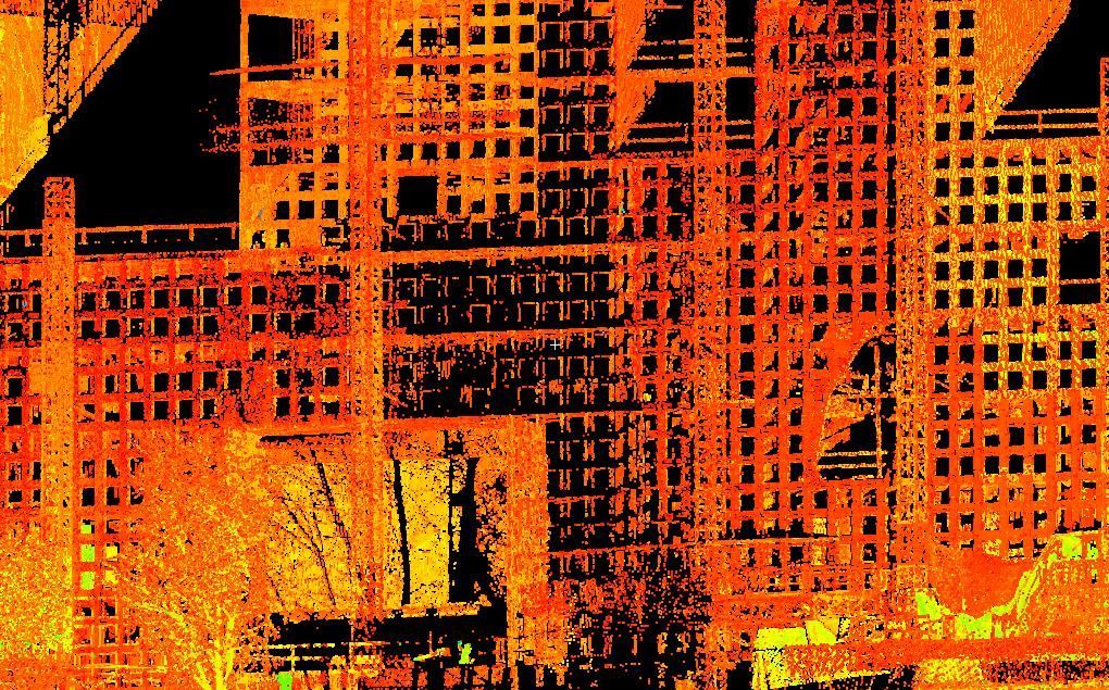 Orange-lit city buildings with dense grid-like windows and silhouettes in a nighttime urban scene