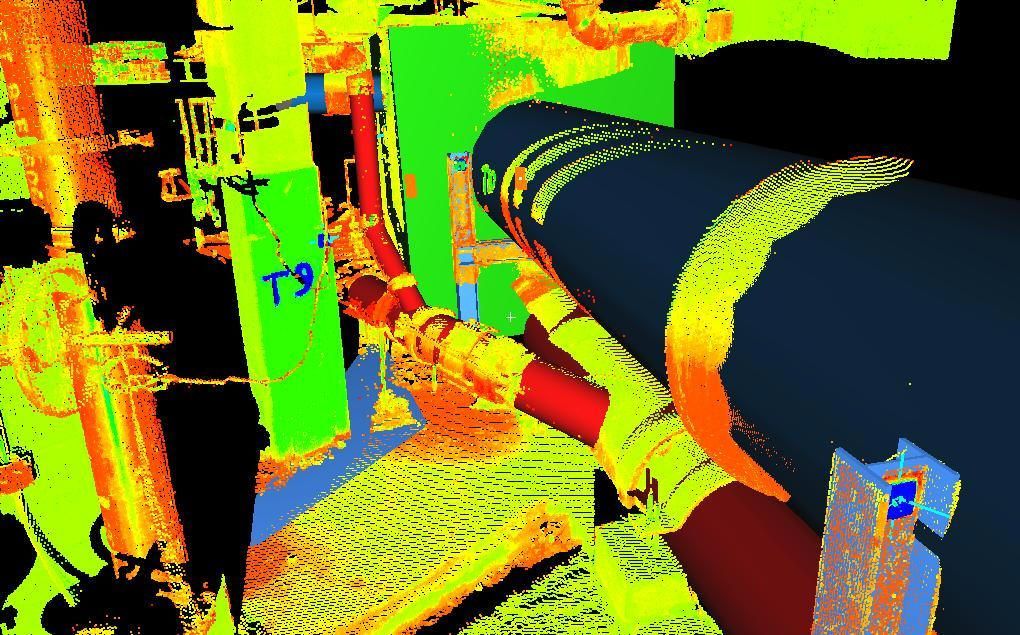 Colorful industrial pipes and machinery in a factory-like setting, shown in bright false colors.