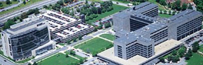 Aerial view of a large modern office campus with multiple gray buildings and green lawns