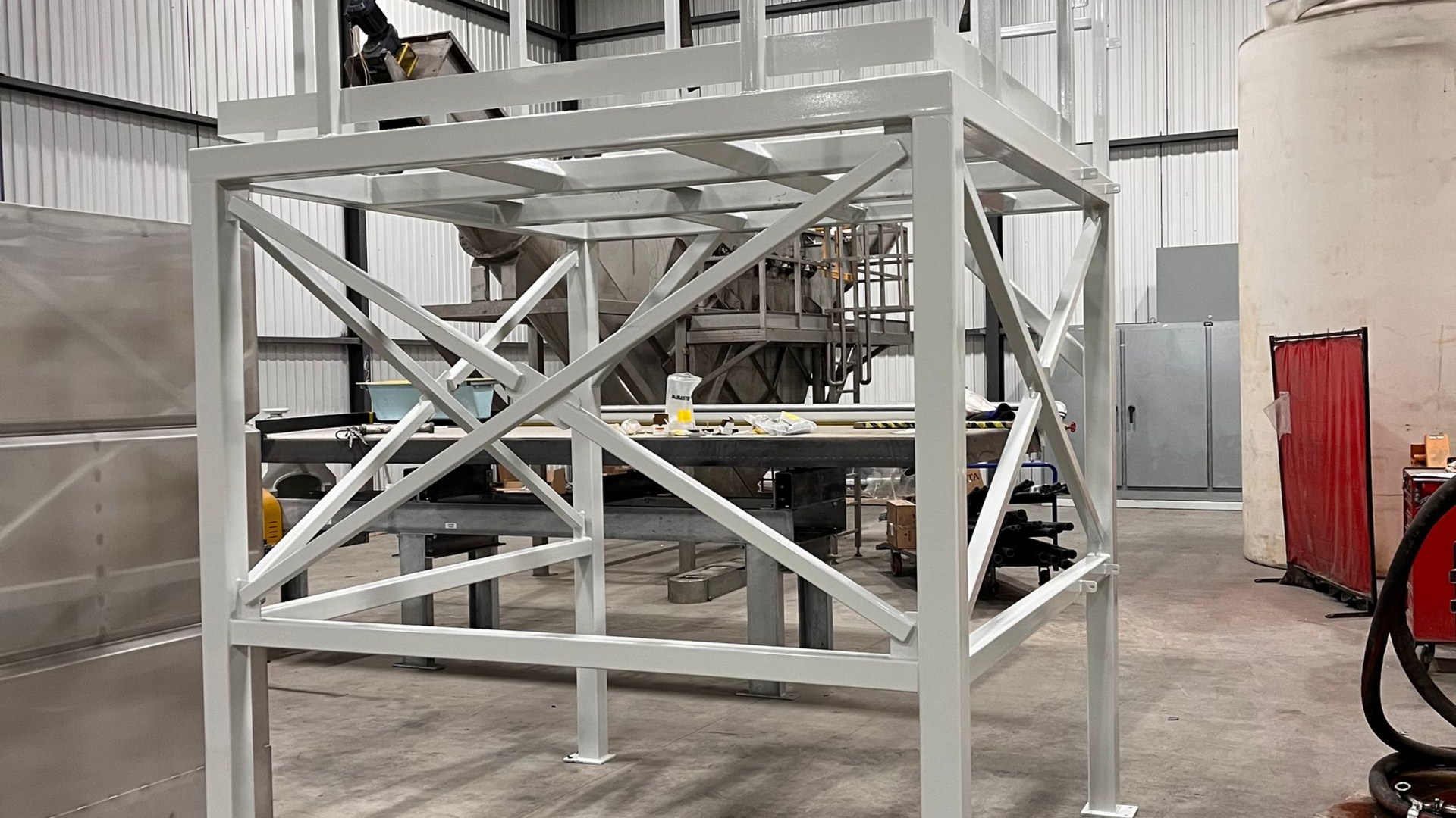 Structure de plate-forme industrielle en métal blanc à l'intérieur d'un bâtiment.