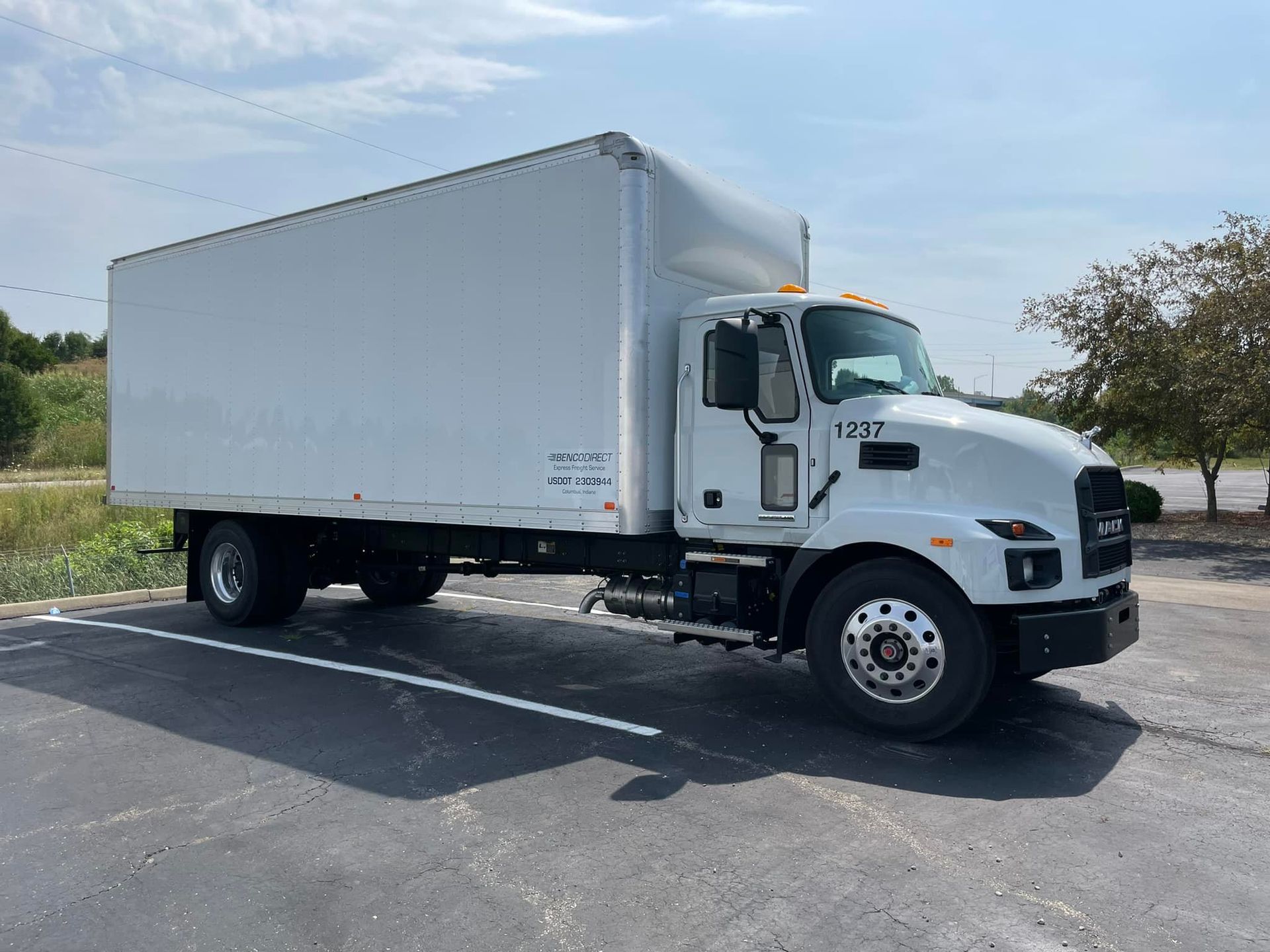 A white box truck is parked in a parking lot.