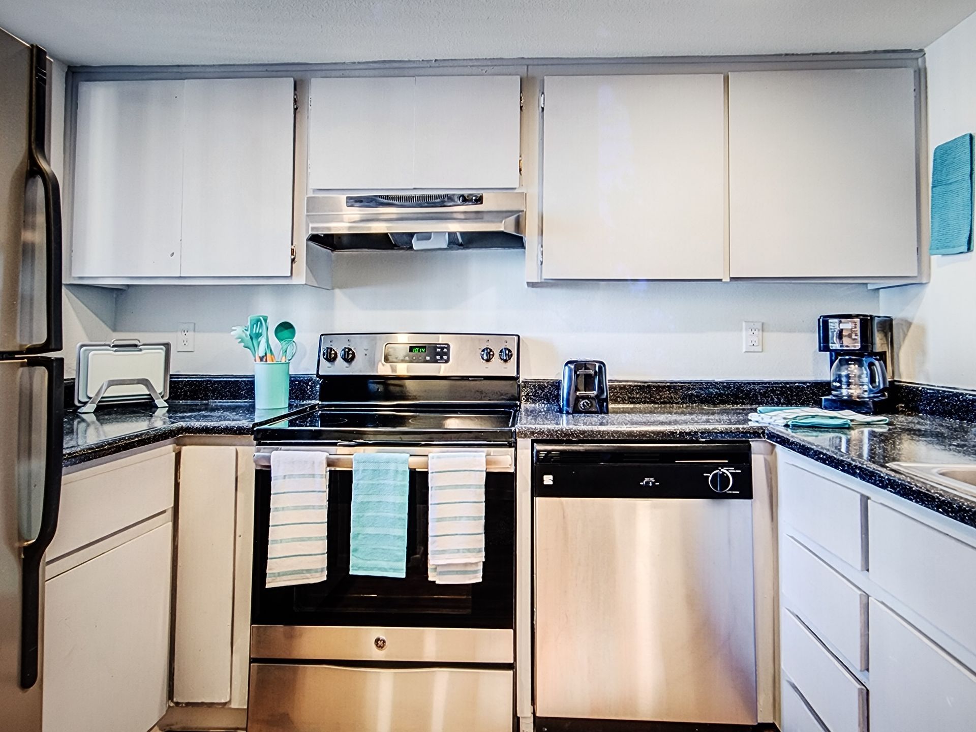 A kitchen with stainless steel appliances and white cabinets.