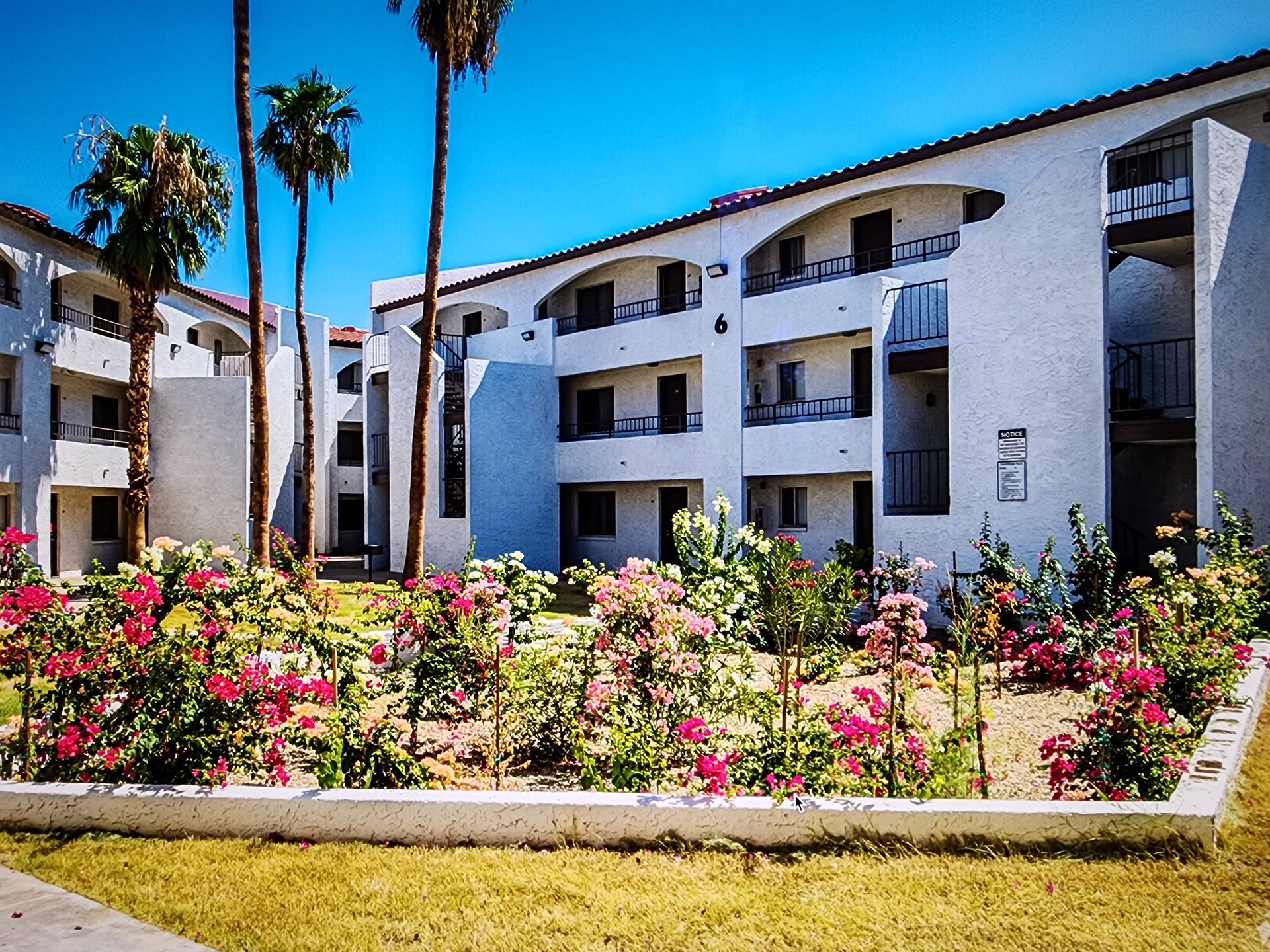 A large white building with flowers in front of it.