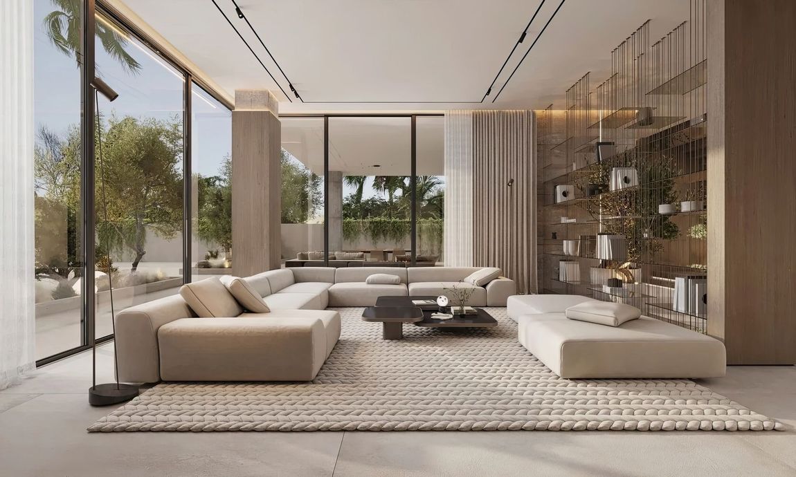 Modern beige living room with floor-to-ceiling windows, low sofas, rug, coffee table, and indoor plants.