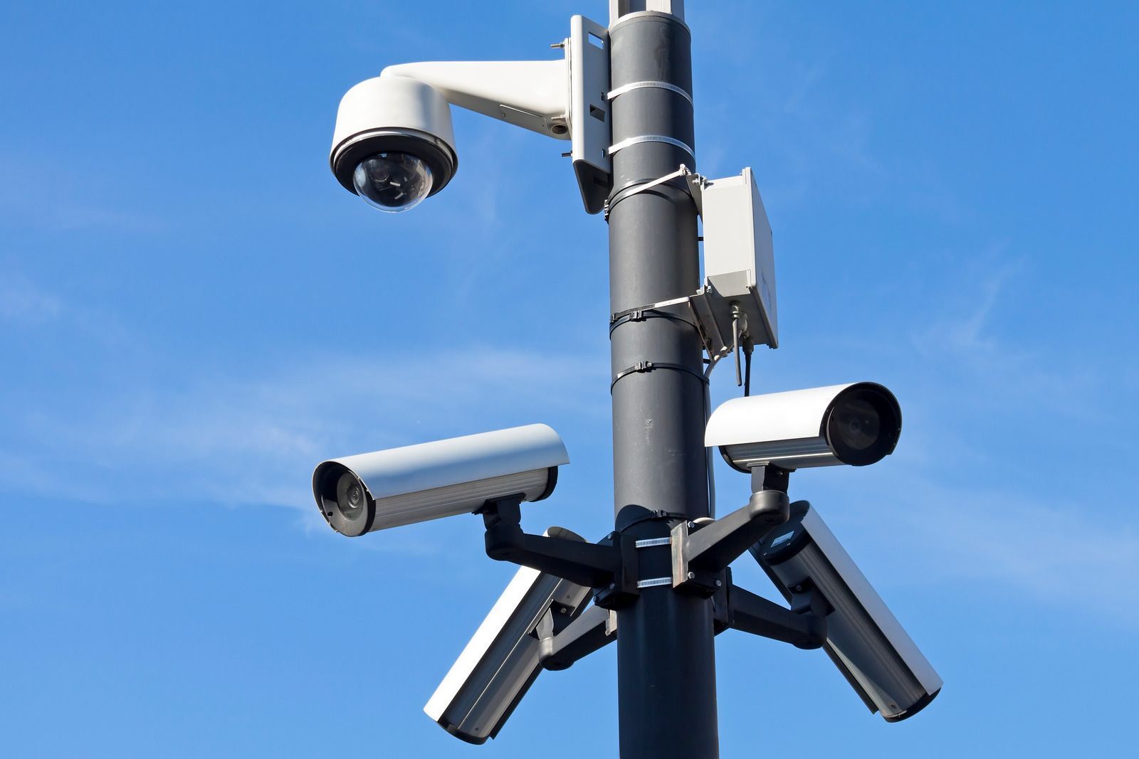 A pole with a bunch of security cameras on it