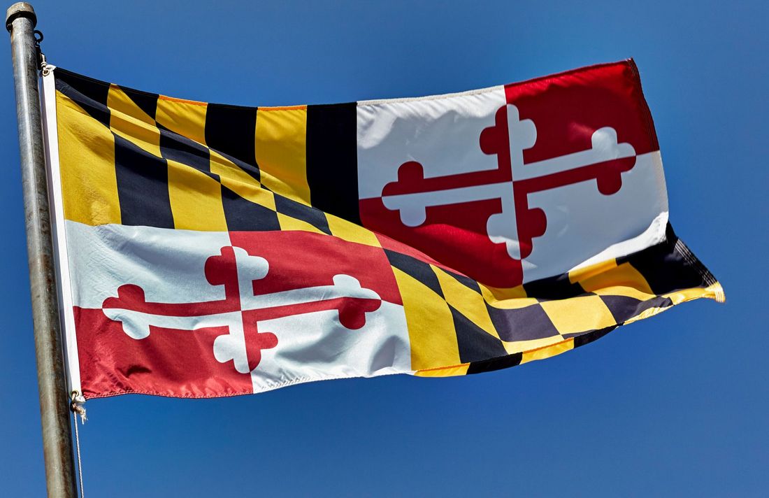 Maryland state flag waving against a blue sky