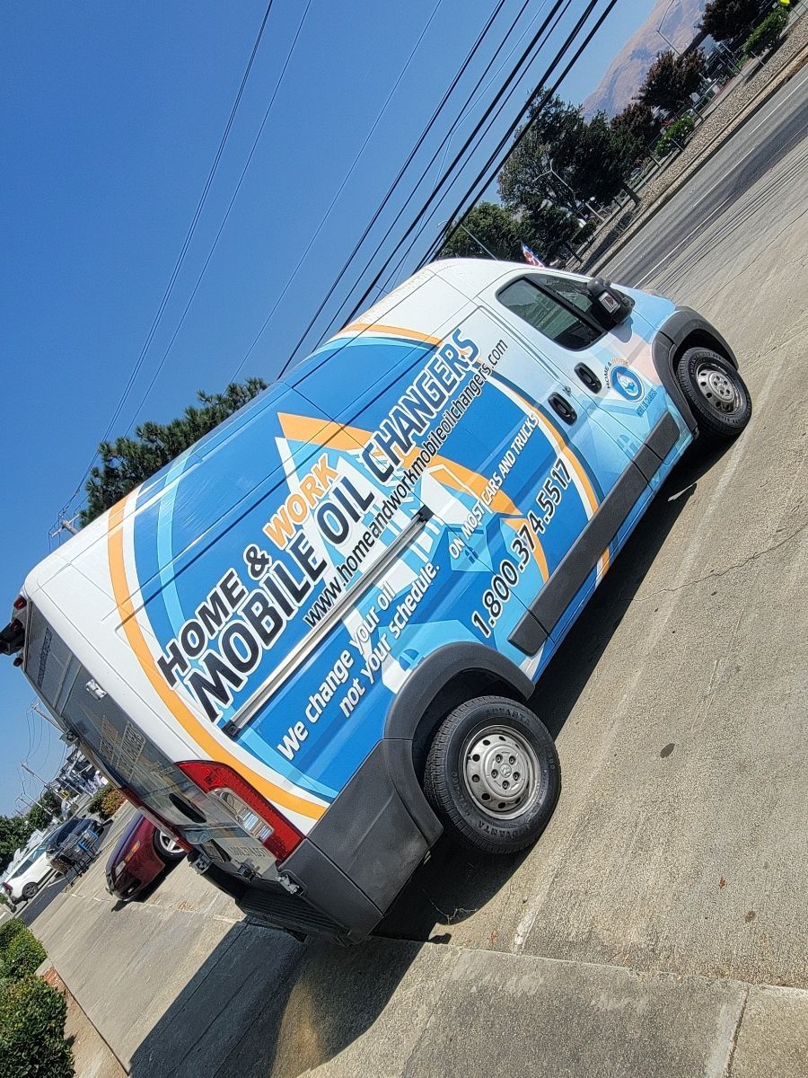 A mobile oil change van is parked on the side of the road.