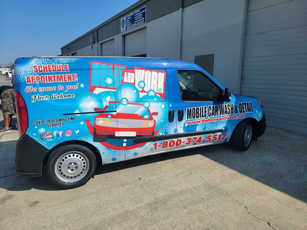 A car wash van is parked in front of a building