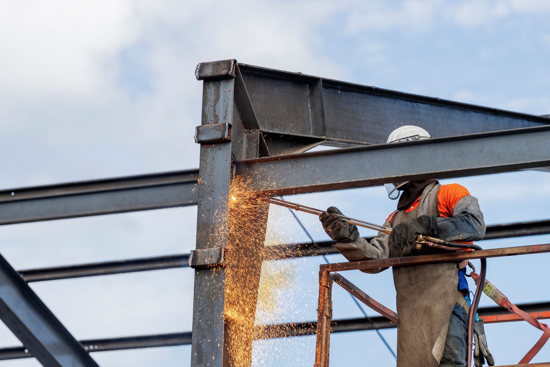 A man is welding a metal structure on a construction site.
