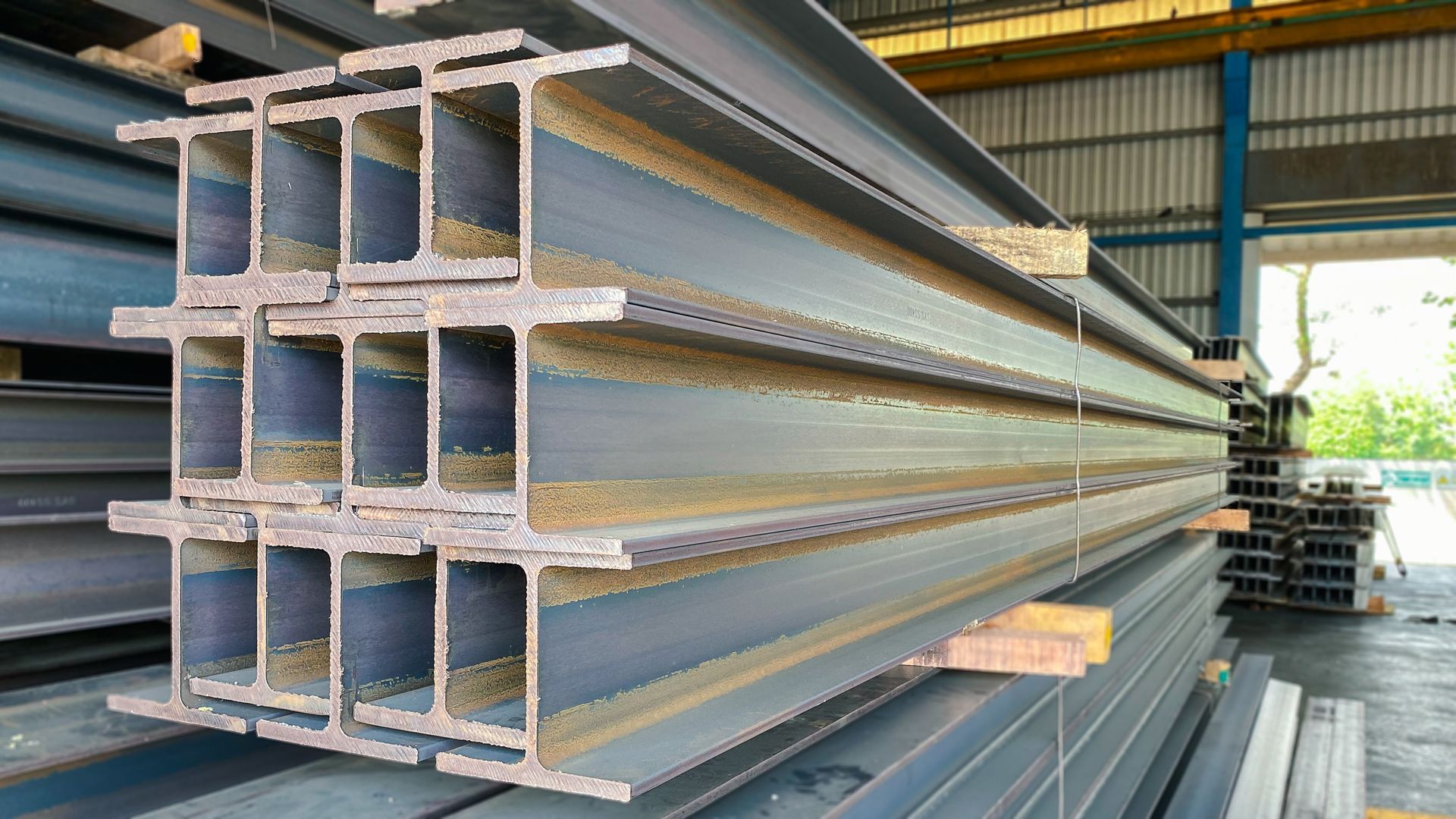 Stacked wide-flange steel I-beams in a warehouse, close-up of cross-sections