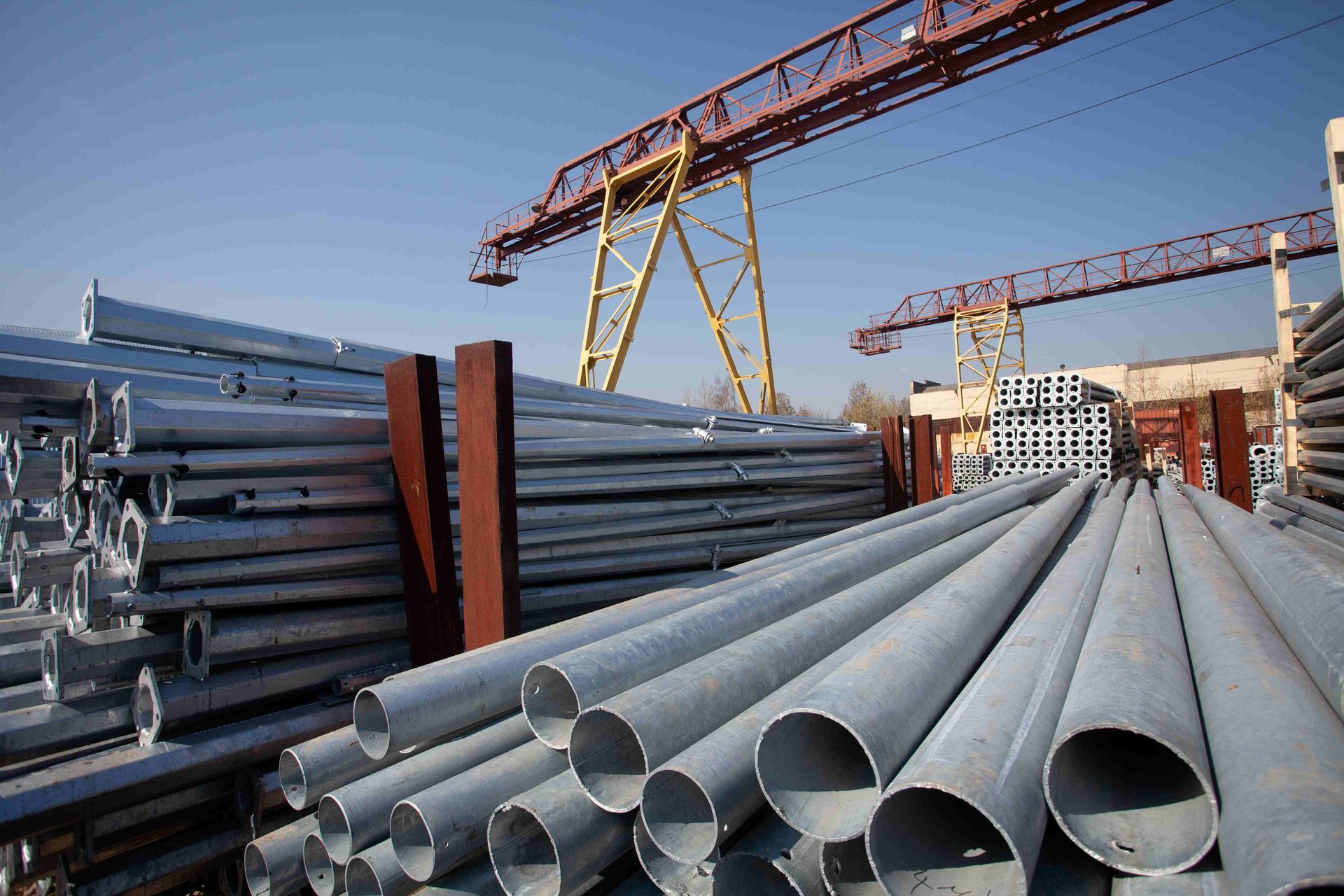 Steel pipes and metal stock stored in an industrial yard, ready for construction projects.