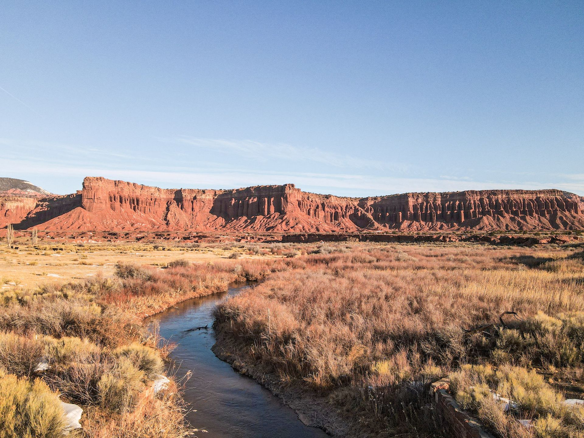 a river running through a desert landscape with mountains in the background .