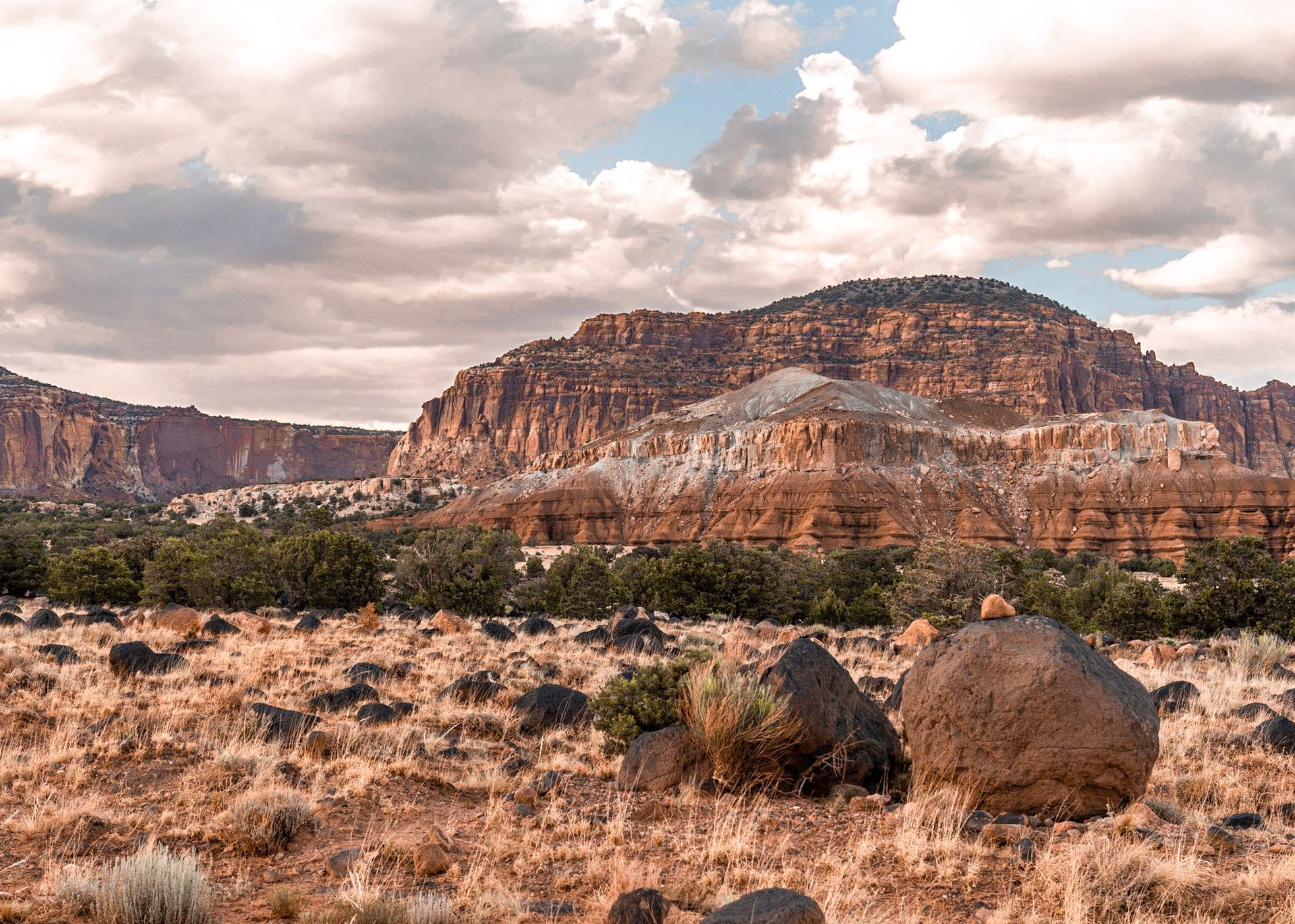 a desert landscape with mountains in the background and a large rock in the foreground .