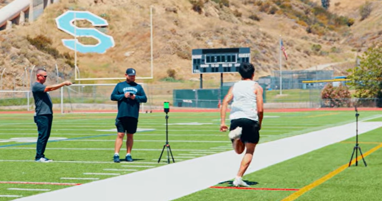 Athlete performing a 40-yard dash during electronic speed testing using SmartSpeed timing gates