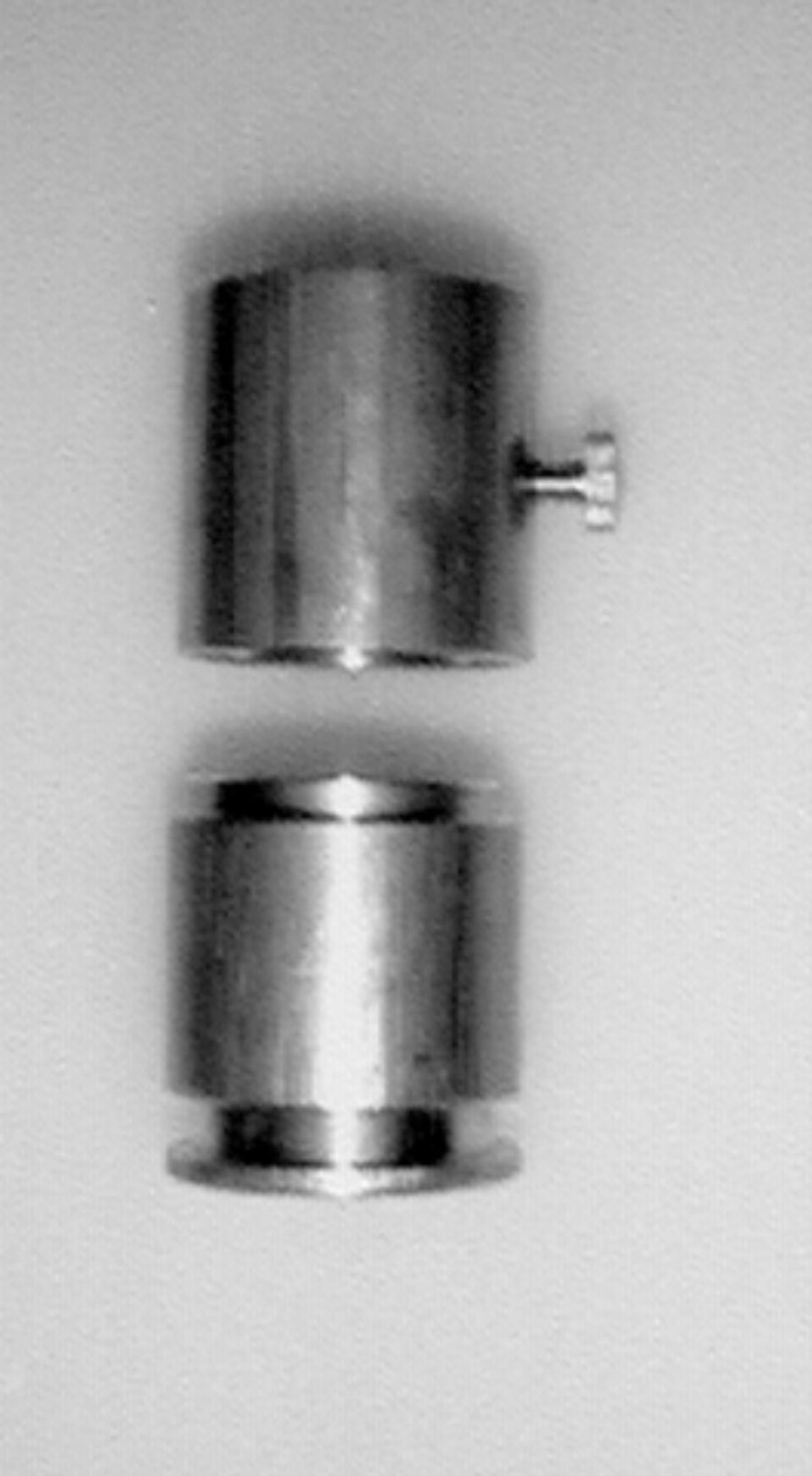 Due parti metalliche cilindriche separate, una con una vite.