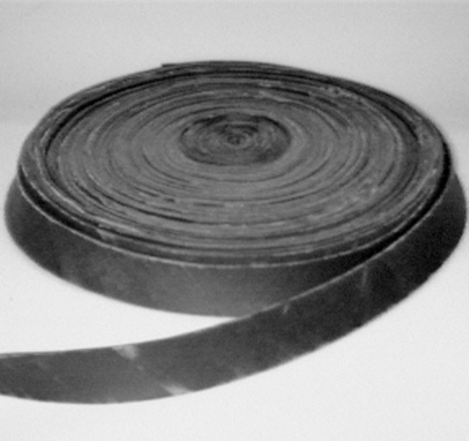 Bobina di materiale piatto e di colore scuro, possibilmente gomma o simile, leggermente srotolata per rivelare la bobina.