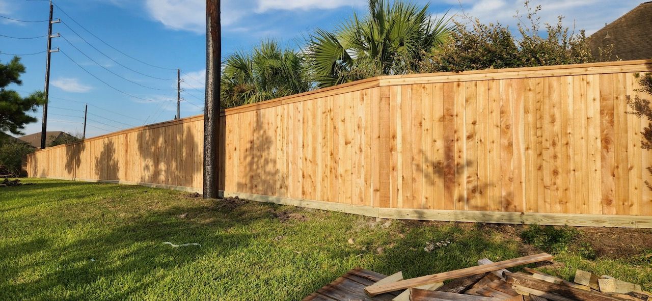 A wooden fence is sitting in the middle of a lush green field.