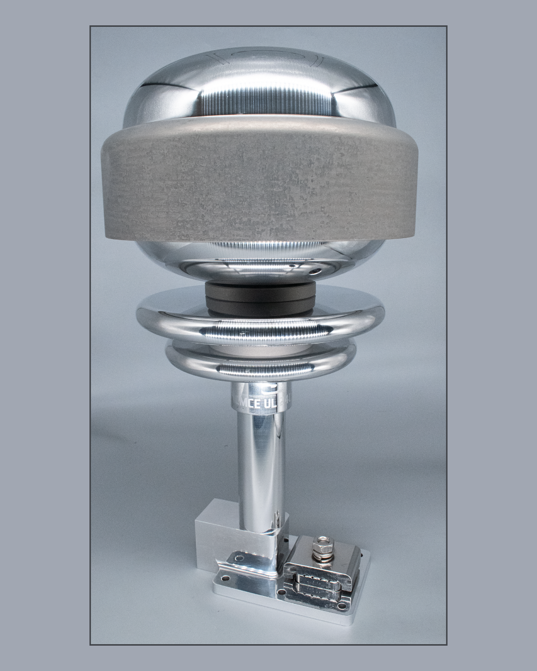 Silver-colored, spherical instrument with a cylindrical base and a square mount. It has a gray band around its middle.