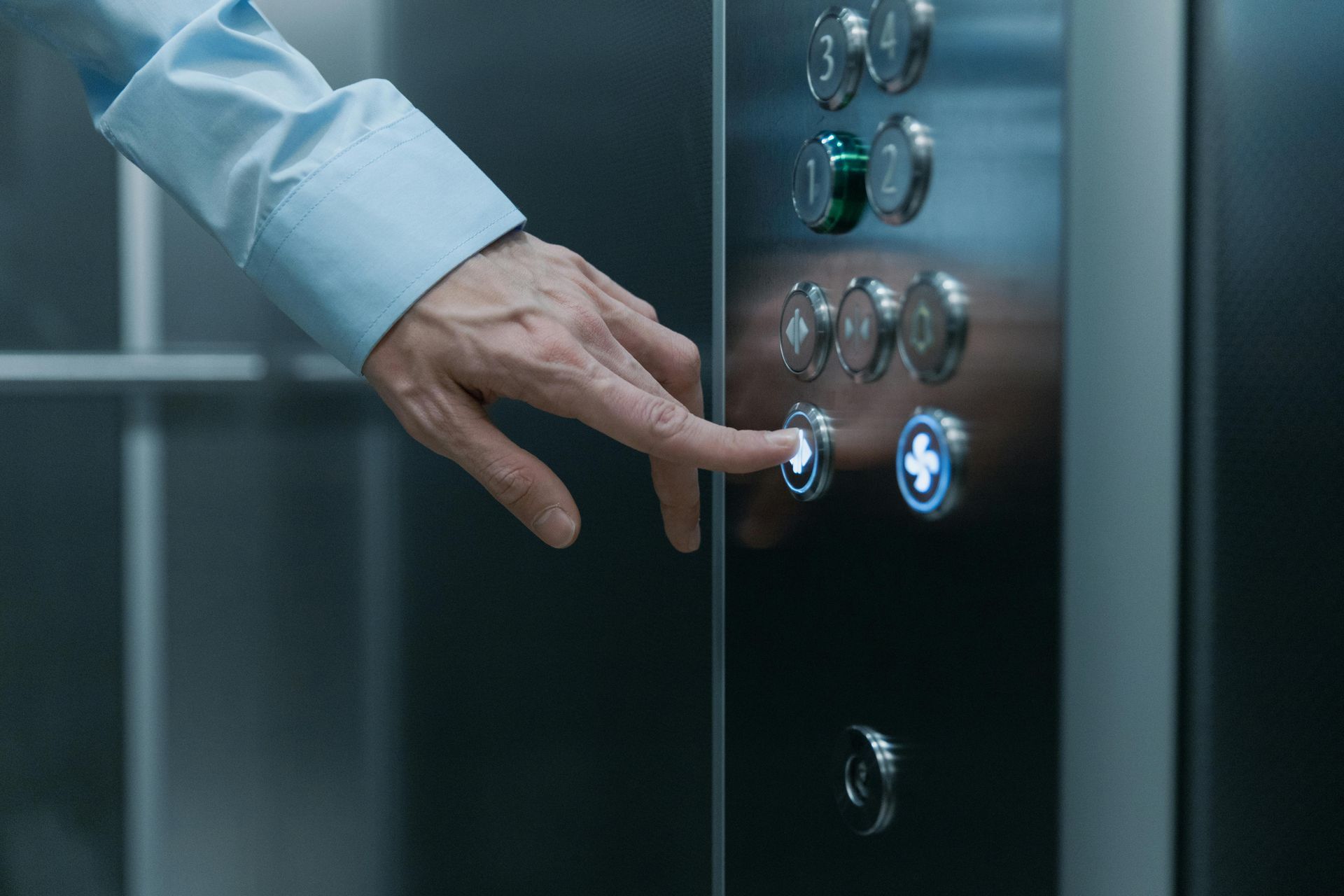 man pushing button on elevator