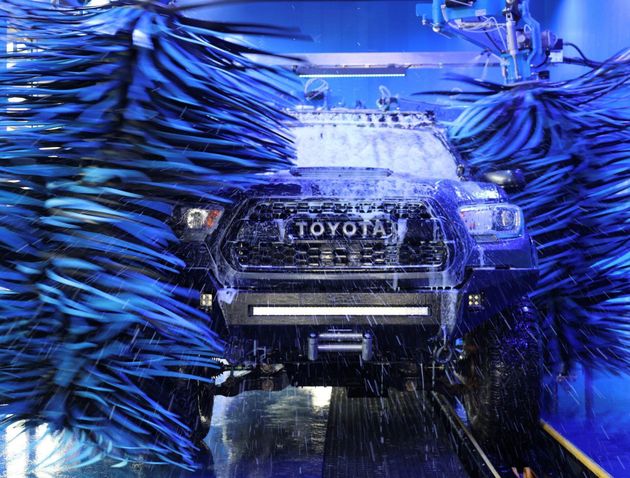 Ottos car wash floridaToyota SUV going through a blue automated car wash, covered in spinning brushes and water.
