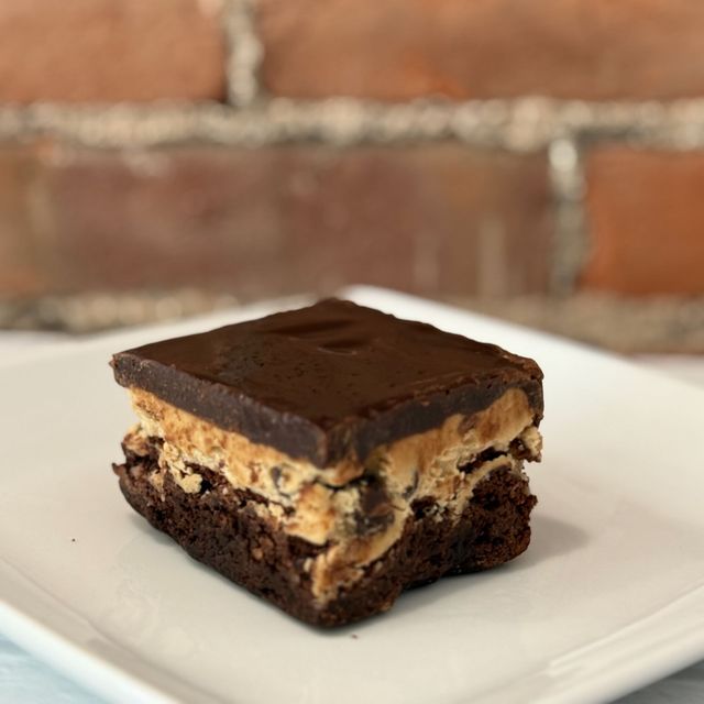 A brownie with peanut butter and chocolate on a white plate