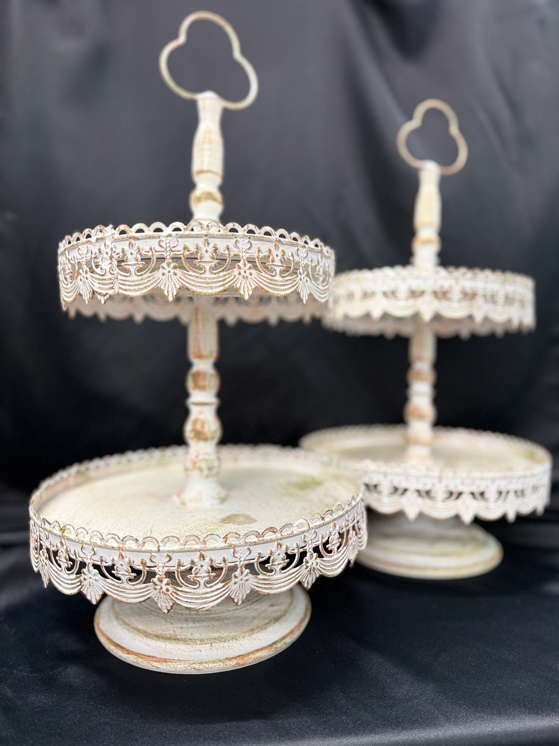 Three white cake stands with keys on top of them
