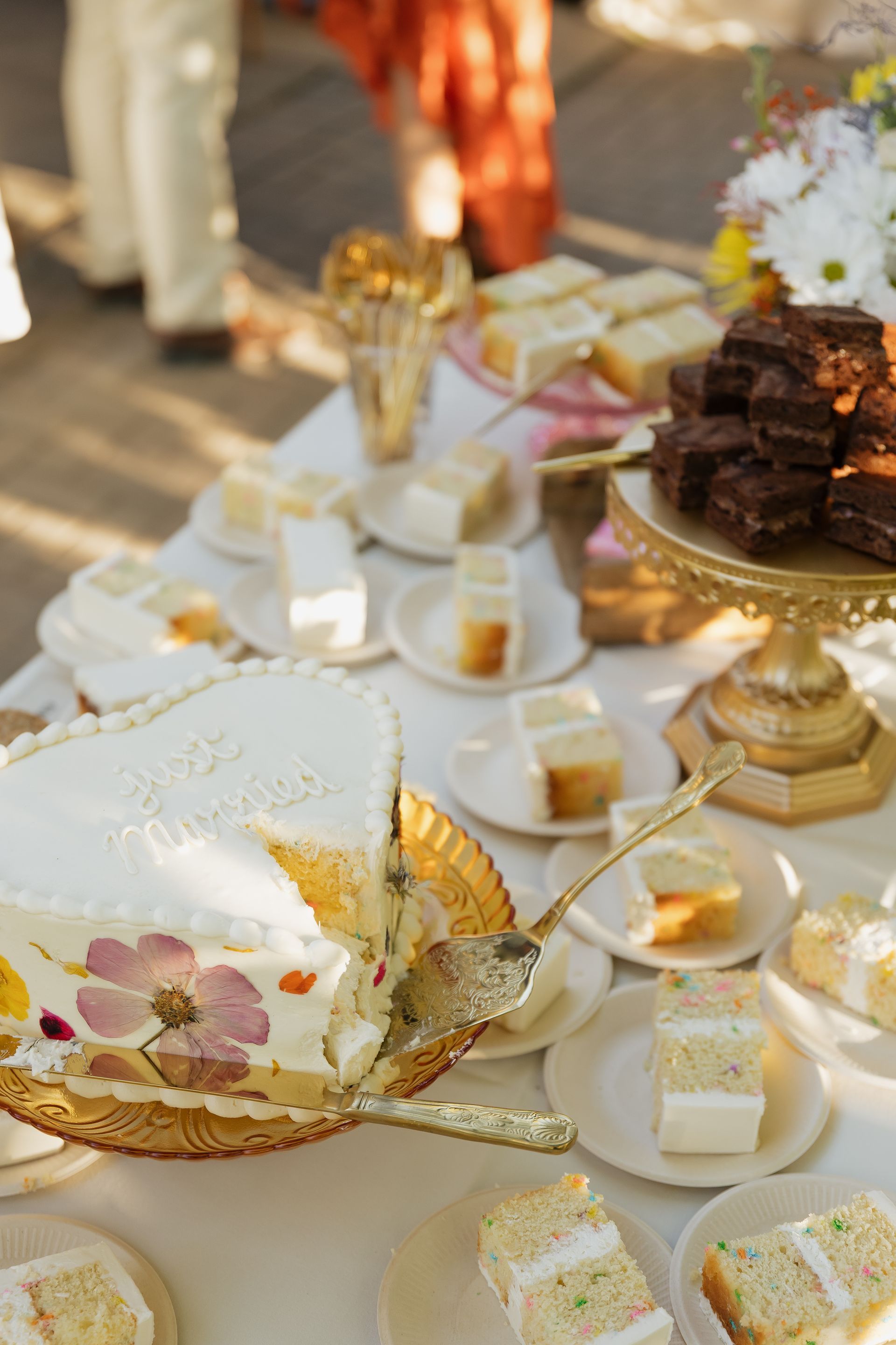 A wedding cake with pink roses and baby 's breath is on a table.