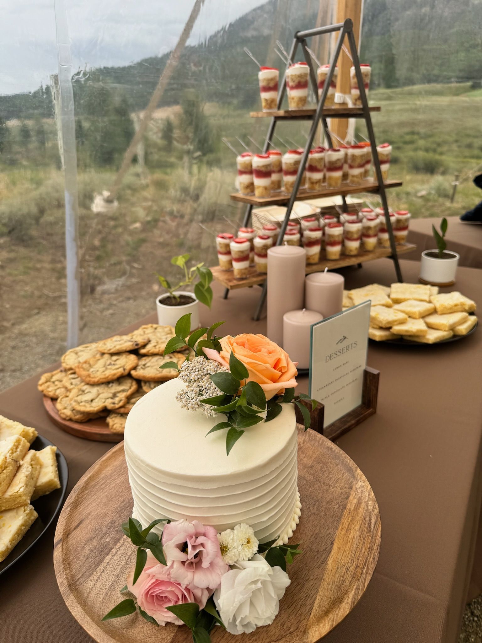 A cake with flowers on top of it is on a table with other desserts.