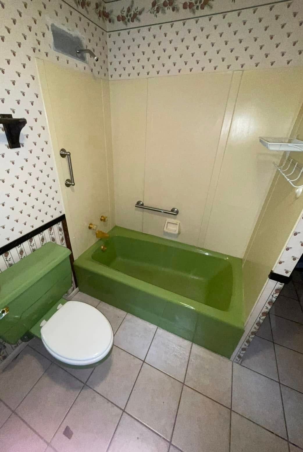 Small bathroom with a green walk-in tub, toilet, grab bars, and tiled floor.