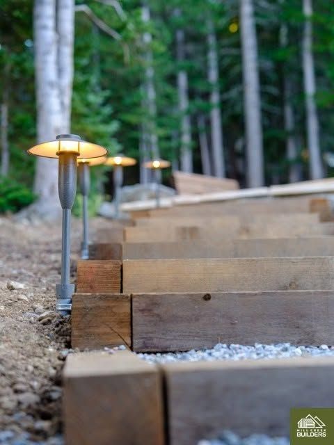 Wooden steps with small path lights in a wooded landscape