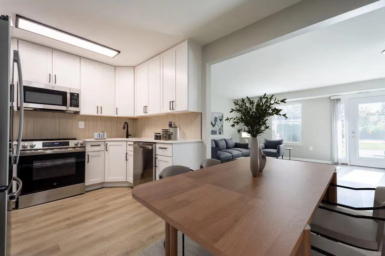Open-concept kitchen with white cabinets and stainless-steel appliances opening to a living area. Visit us at Fox Ridge & Lakeview Park Apartments and view our pet-friendly apartments for rent in Limerick, PA.