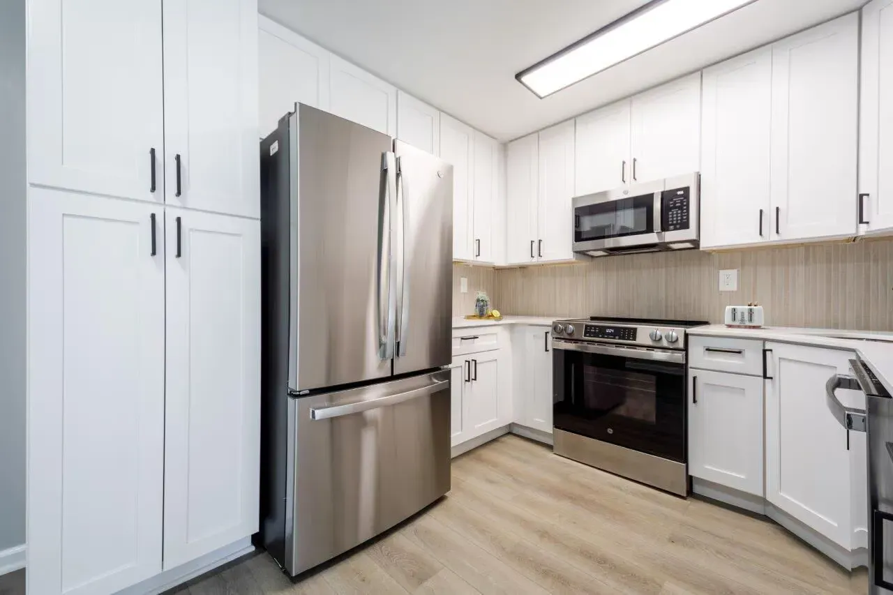 Modern white kitchen with stainless steel refrigerator, oven, microwave, and cabinetry. Visit us at Fox Ridge & Lakeview Park Apartments and view our apartments for rent in Limerick, PA.