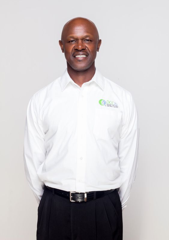 A man in a white shirt and black pants is smiling