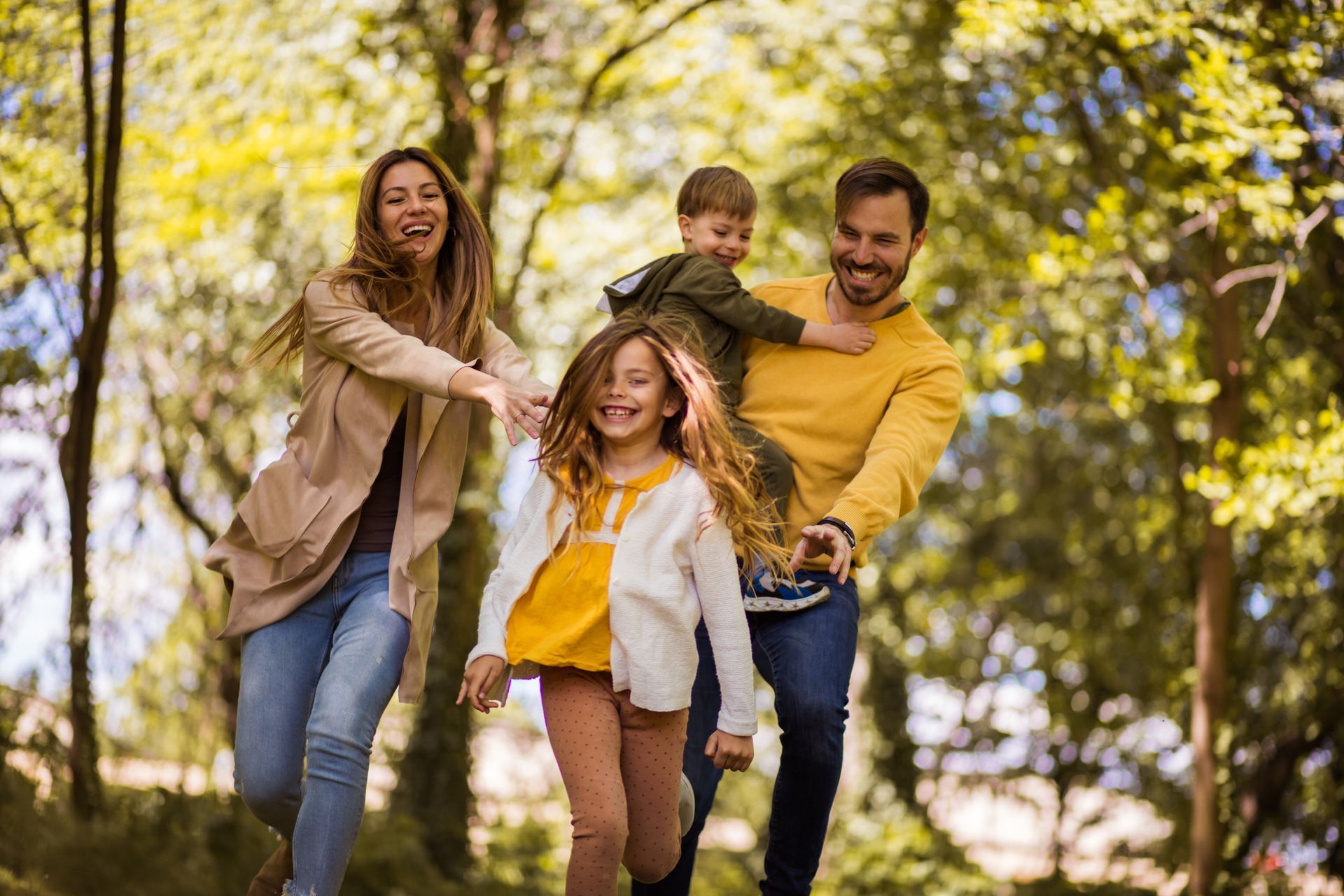 Parents and two young children running and laughing together