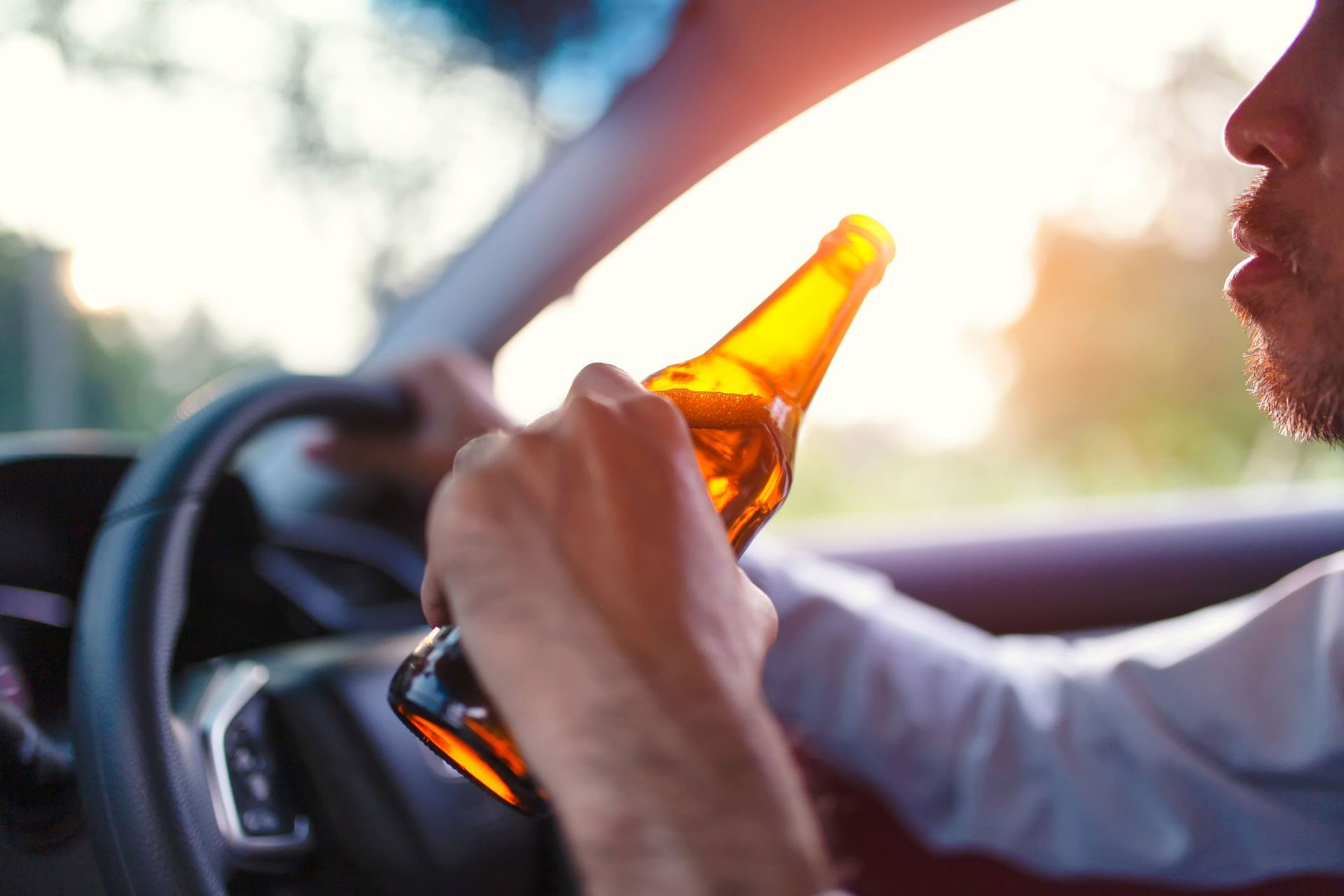 Drunk Asian Young Man Drives A Car With A Bottle Of Beer — Green Bay, WI — Brabazon Law Office LLC Drunk Asian Young Man Drives A Car With A Bottle Of Beer — Green Bay, WI — Brabazon Law Office LLC