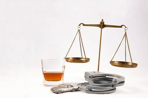 Justice balance with a car, handcuffs, and drink for drunk driver attorneys at Brabazon Law Office in De Pere, WI.
