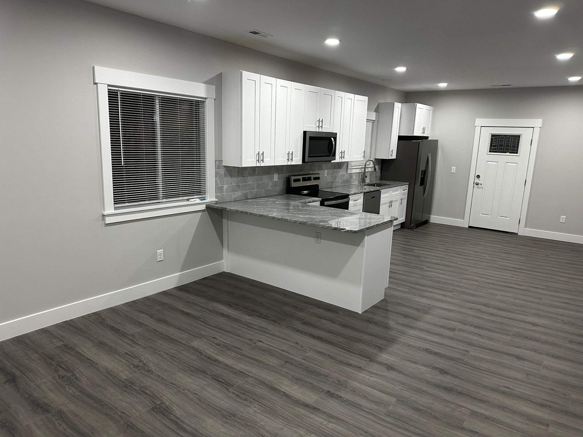 A black and white photo of a kitchen in a house.