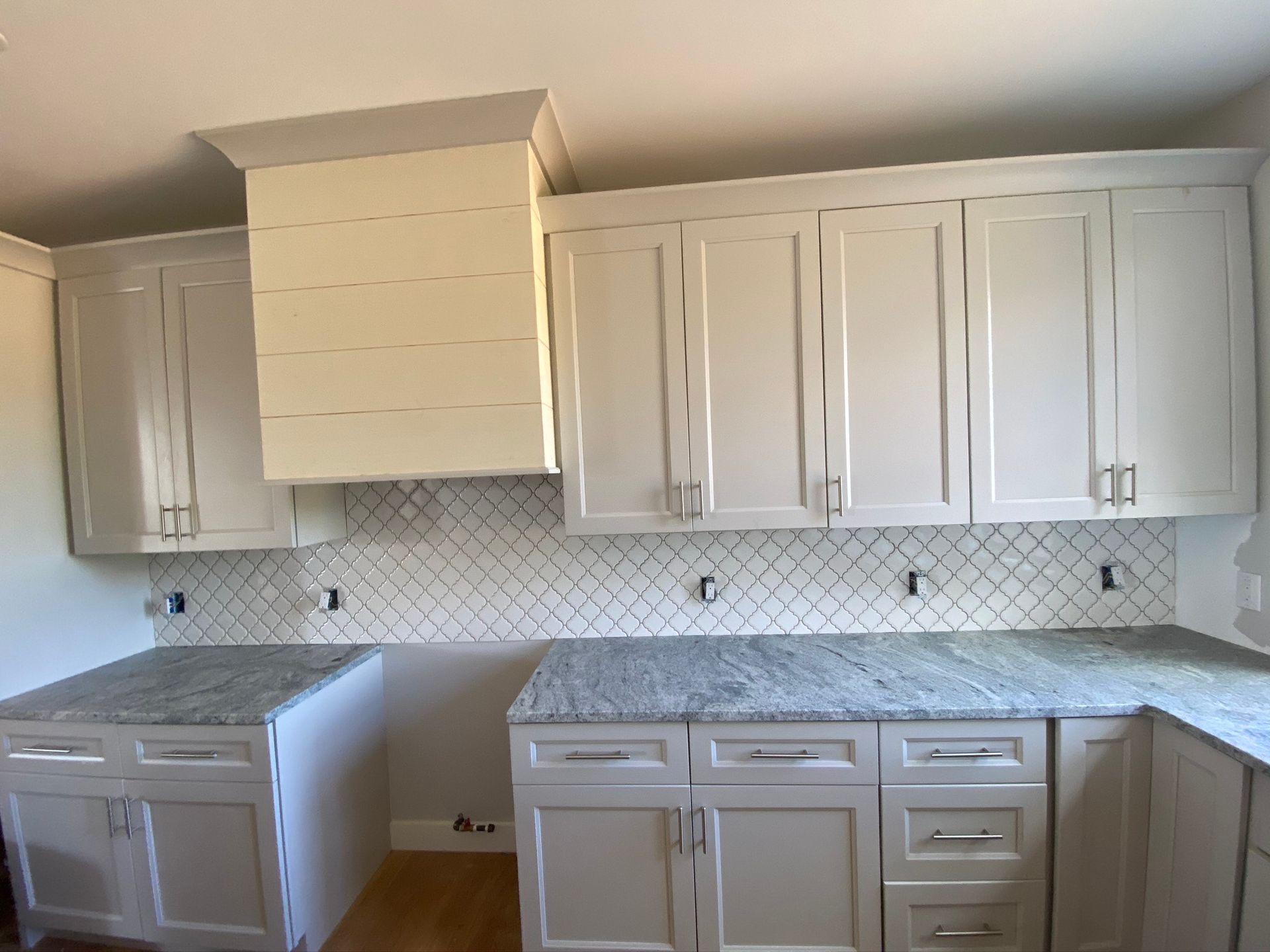 A kitchen with white cabinets and granite counter tops