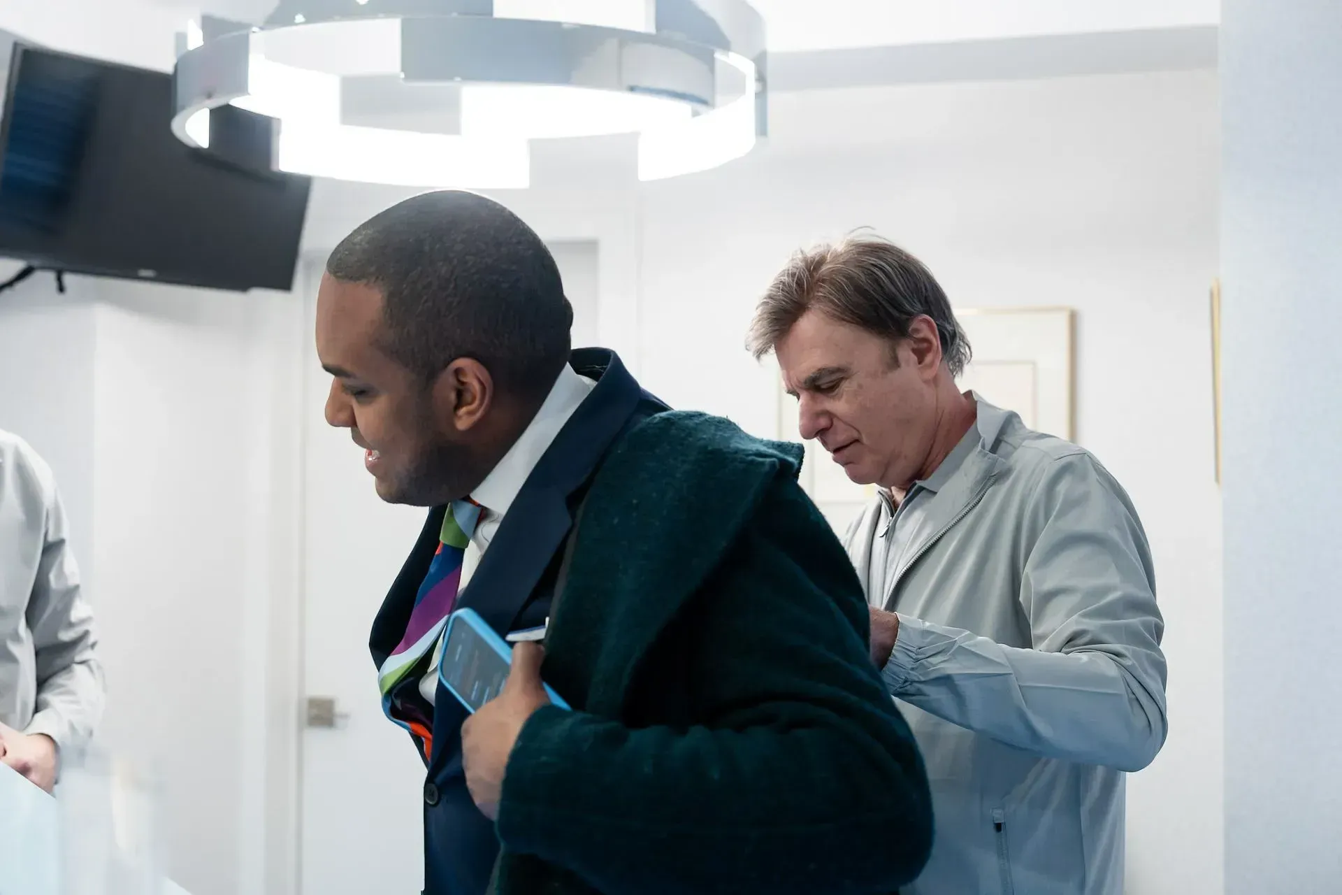 Dr. Daniel Wank helping a patient into a coat
