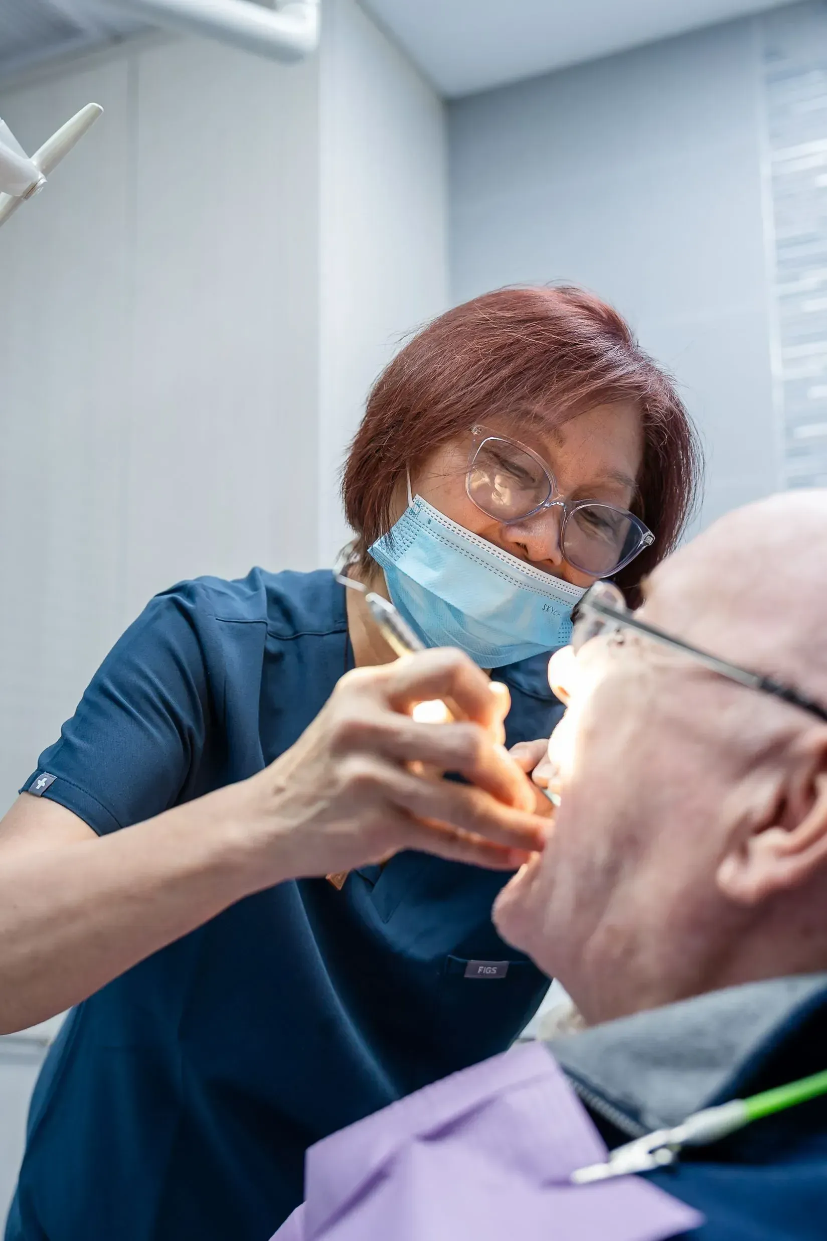A dental team member examining a patient’s teeth