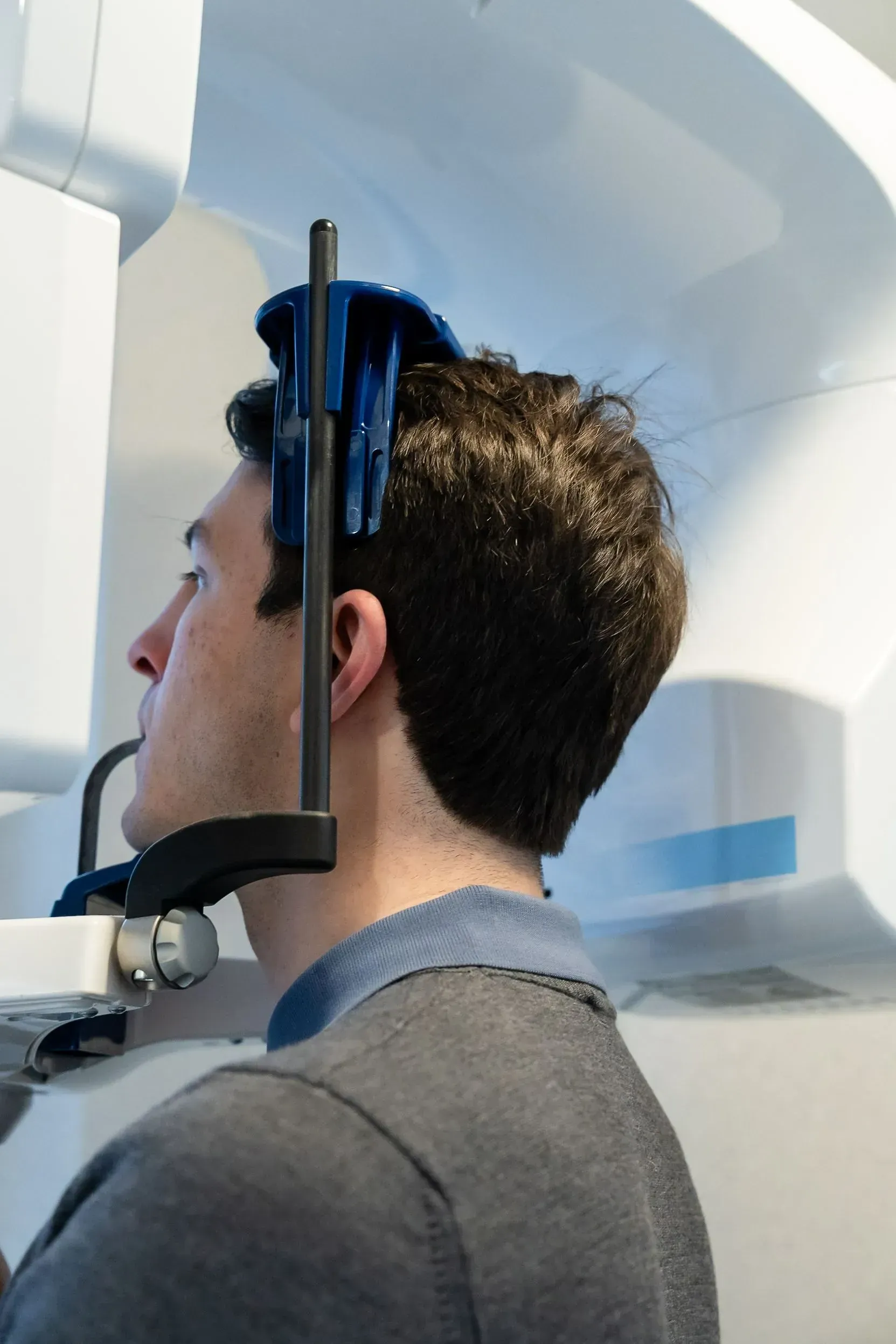 A patient standing in the office’s 3D dental scanner