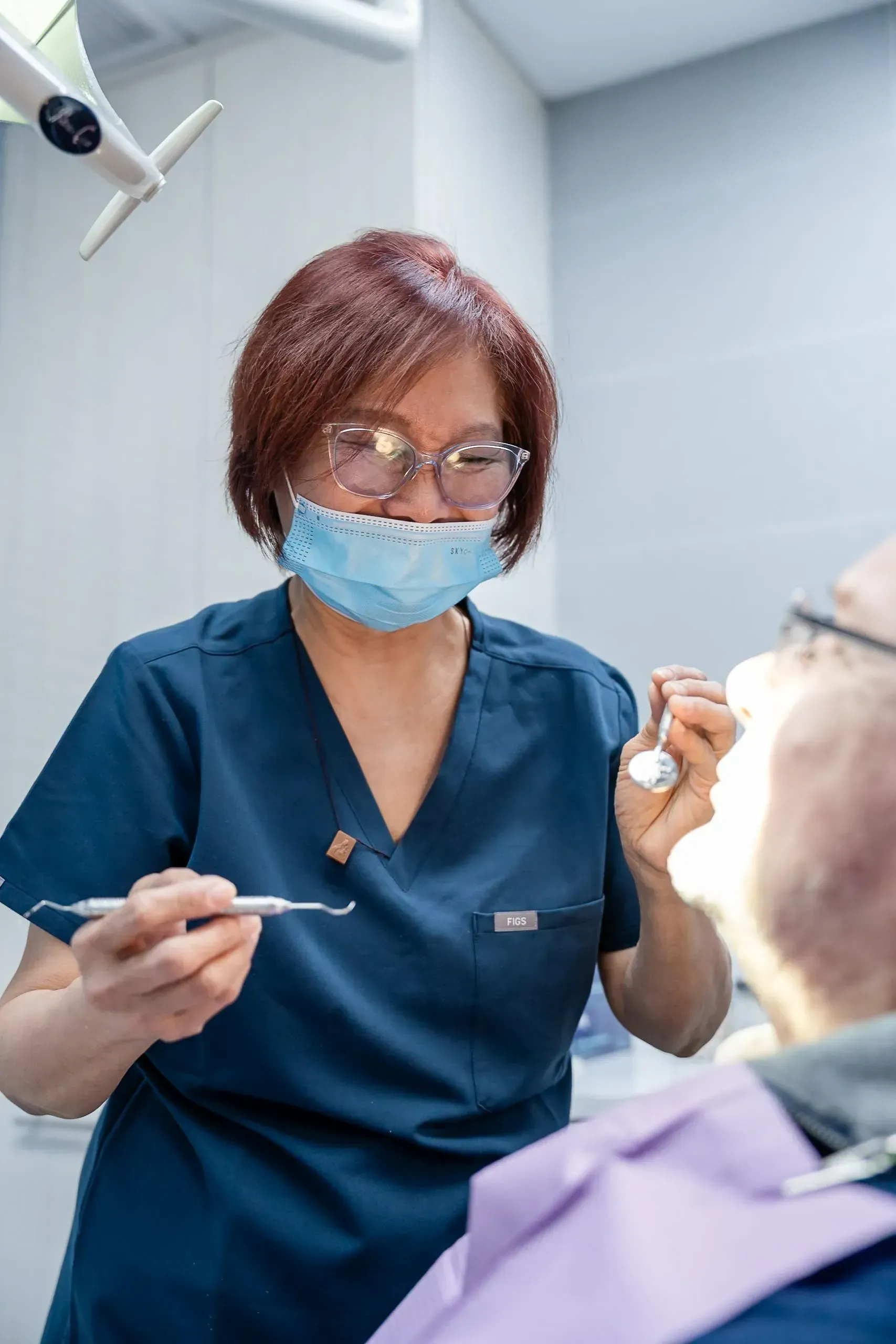 A dental team member cleaning a patient’s teeth