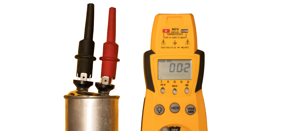 Yellow digital multimeter beside red and black probes measuring a metal cylinder battery cell