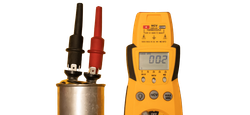 Yellow digital multimeter beside red and black probes measuring a metal cylinder battery cell