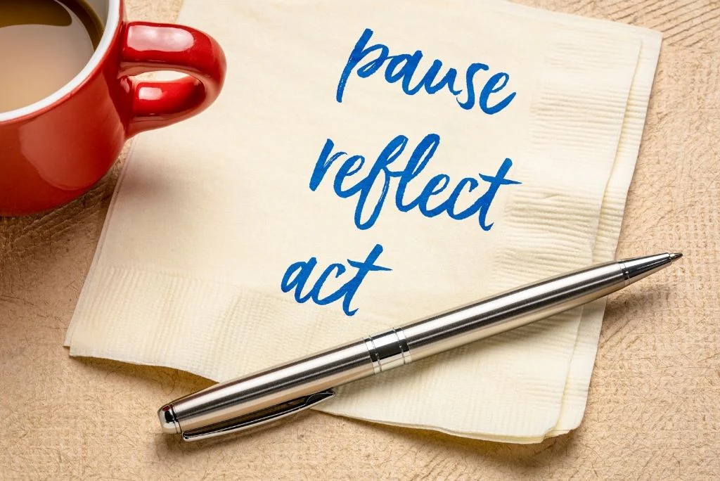 A napkin with the words `` pause reflect act '' written on it next to a pen and a cup of coffee.